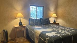a bedroom with a bed with two lamps and a window at Cuddle Up in Ruidoso