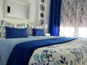 プエルト・デ・ラ・クルスにあるRosmaryのベッドルーム1室(青と白のベッド、青の枕付)