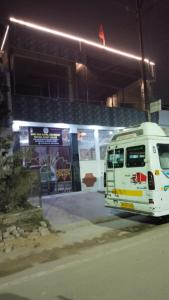 un autobús blanco estacionado frente a una gasolinera en Shri Ram Gopal Residency, en Faizābād