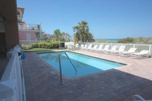 uma piscina com espreguiçadeiras brancas em redor em 101 Casa de Playa em Clearwater Beach