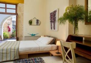 a bedroom with a bed and a desk and a window at Historic Venetian Castle ideal for family events! in Maroulás +45 photos