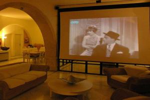 a large screen in a living room with a movie at Historic Venetian Castle ideal for family events! in Maroulás
