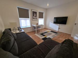 a living room with a couch and a tv at Split level luton town center flat in Luton