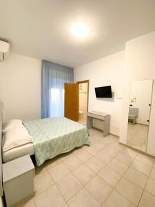 una camera con letto, specchio e TV di Appartamenti Vacanze Vista mare ad Alba Adriatica