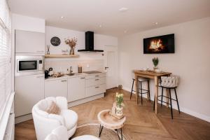 a kitchen with white cabinets and a table at Casa la Vida Beach House in Zandvoort