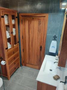 uma casa de banho com um lavatório e um armário de madeira em Quinta Erva Doce em Vila do Porto