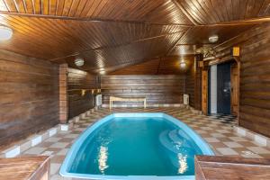 a jacuzzi tub in a room with a wooden ceiling at Вілла ЮРАН Східниця in Skhidnitsa