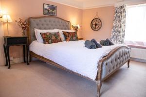 1 dormitorio con 1 cama grande con sábanas y almohadas blancas en Post Office Cottage en Weymouth