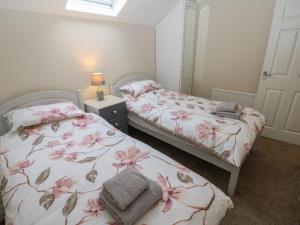 a bedroom with two beds with pink flowers at Jasmine Cottage in Richmond