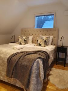 sypialnia z dużym łóżkiem i dużym oknem w obiekcie three bedrooms villa segersjö w mieście Tumba
