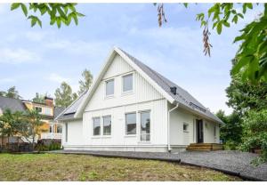 una casa blanca con techo de gambrel en three bedrooms villa segersjö, en Tumba