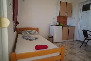 małą sypialnię z łóżkiem i małą kuchnię w obiekcie Apartments Safija w Dobrej Vodzie