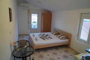 sypialnia z łóżkiem, krzesłem i oknem w obiekcie Apartments Safija w Dobrej Vodzie