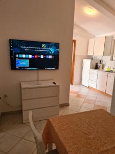 a living room with a flat screen tv on the wall at Adria Arba Apartments in Rab