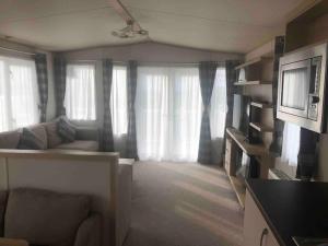 a living room with a couch and some windows at Luxurious Lodging in Bembridge in Bembridge