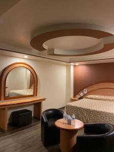 メキシコシティにあるHotel Gran Víaのベッドと鏡が備わるホテルルーム