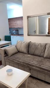 Sofá marrón en la sala de estar con mesa en Apartment BN MAGIC, en Bijeljina