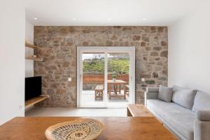 a living room with a couch and a table at ĪKADE Mykonos in Mýkonos City