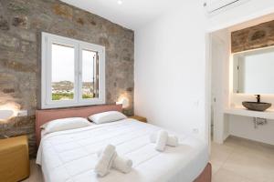 Ένα ή περισσότερα κρεβάτια σε δωμάτιο στο ĪKADE Mykonos +45 φωτογραφίες