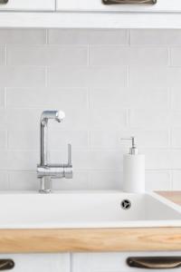 a white kitchen sink with a faucet at ĪKADE Mykonos in Mýkonos City