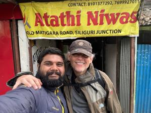 deux hommes se tiennent devant un magasin dans l'établissement Atathi Niwas Guest House for Backpackers and Travellers, à Siliguri