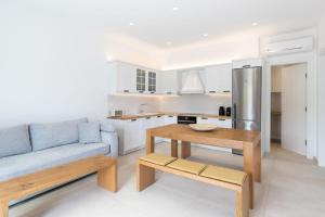 a living room with a blue couch and a table at ĪKADE Mykonos in Mikonos