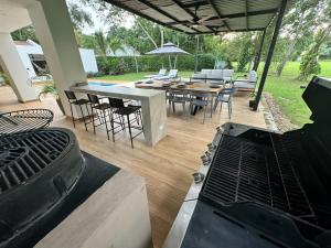 a patio with a grill and a table and chairs at Casa Privada en Exclusivo Club Privado in Ricaurte
