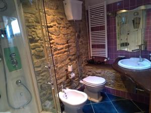 a bathroom with a toilet and a sink and a shower at MuntaeCara Hotel Diffuso in Apricale