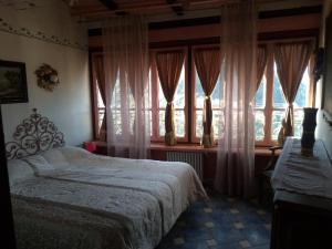 a bedroom with a bed in front of a window at MuntaeCara Hotel Diffuso in Apricale