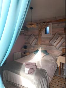 1 dormitorio con 1 cama con toallas en La Taverne en Buire-le-Sec