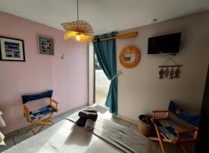 salon z dużym oknem i 2 krzesłami w obiekcie La Taverne w mieście Buire-le-Sec