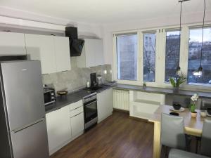 ワルシャワにあるUroczy apartament dla 4 osóbの白いキャビネットと木製テーブル付きのキッチン
