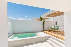 ein weißes Haus mit einem Pool und 2 Stühlen in der Unterkunft Masseria Pensato - Exclusive Lodges with Private Pool in Savelletri di Fasano