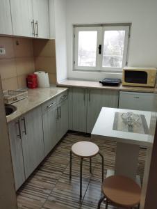 a small kitchen with a table and two chairs at Sobe Popovica in Soko Banja