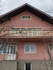a pink house with windows and a balcony at Sobe Popovica in Soko Banja
