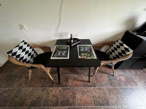 una mesa negra con 2 sillas y una mesa en blanco y negro en B&B De Handwijzer Hengelo en Hengelo