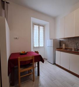 a small kitchen with a table with a red table cloth at Da Vinci Refuge 1 in Limonta
