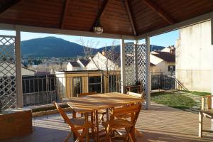 een terras met een houten tafel en stoelen op een balkon bij Nootka in San Rafael