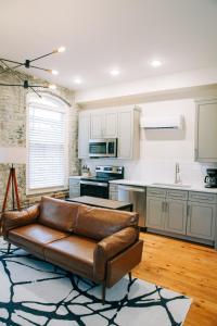 ein Wohnzimmer mit einer braunen Couch in einer Küche in der Unterkunft The St. Clair in Frankfort