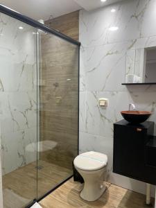 a bathroom with a toilet and a glass shower at Maxi Palace hotel in Capitão Leônidas Marques