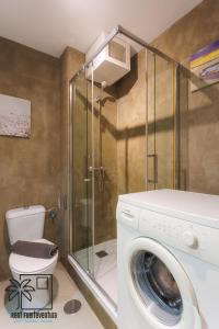 uma máquina de lavar roupa na casa de banho com um chuveiro em Casa Design In the center by iRent Fuerteventura em Corralejo