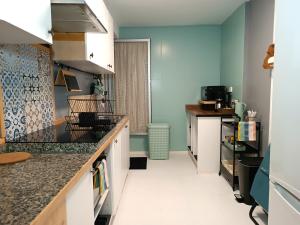 une cuisine avec des murs bleus et un comptoir. dans l'établissement Apartamento en la Playa - Alicante, Costa Blanca - Los Olivos, à Alicante