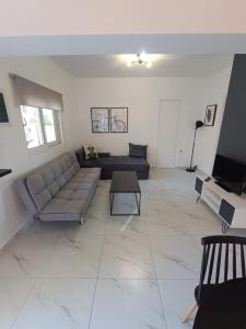 uma sala de estar com um sofá e uma mesa em Alexander apartments em Spartià