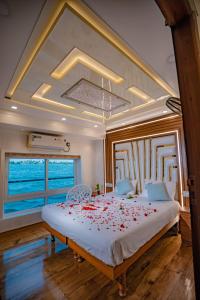 a bedroom with a large bed with red flowers on it at Alice Houseboats Alleppey in Alleppey