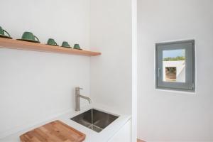 eine Küche mit einem Waschbecken und einem Spiegel in der Unterkunft Masseria Pensato - Exclusive Lodges with Private Pool in Savelletri di Fasano + 44 Fotos