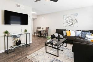 uma sala de estar com um sofá e uma televisão de ecrã plano em Desert Skyline Apt W/Pool & more em Phoenix