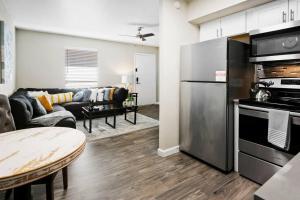 uma cozinha e sala de estar com um frigorífico de aço inoxidável em Desert Skyline Apt W/Pool & more em Phoenix