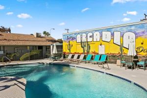uma piscina com cadeiras e um mural num edifício em Desert Skyline Apt W/Pool & more em Phoenix