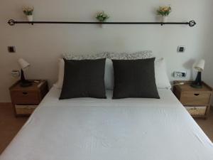 1 dormitorio con 1 cama blanca y 2 mesitas de noche en VENEZIOLA TRAVEL, relax & beach en La Manga del Mar Menor