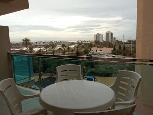 - Balcón con mesa y sillas y vistas a la ciudad en VENEZIOLA TRAVEL, relax & beach, en La Manga del Mar Menor